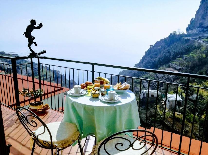 a table topped with plates of food on top of a balcony at Domus Gaia in Amalfi