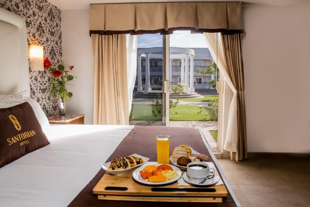 bandeja de desayuno en una cama en una habitación de hotel en Hotel Santorian, en Hermosillo