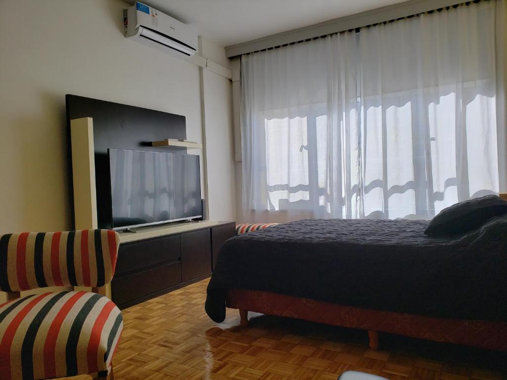 Schlafzimmer mit einem Bett und einem Flachbild-TV in der Unterkunft Maipu Apartament Premiun in Buenos Aires