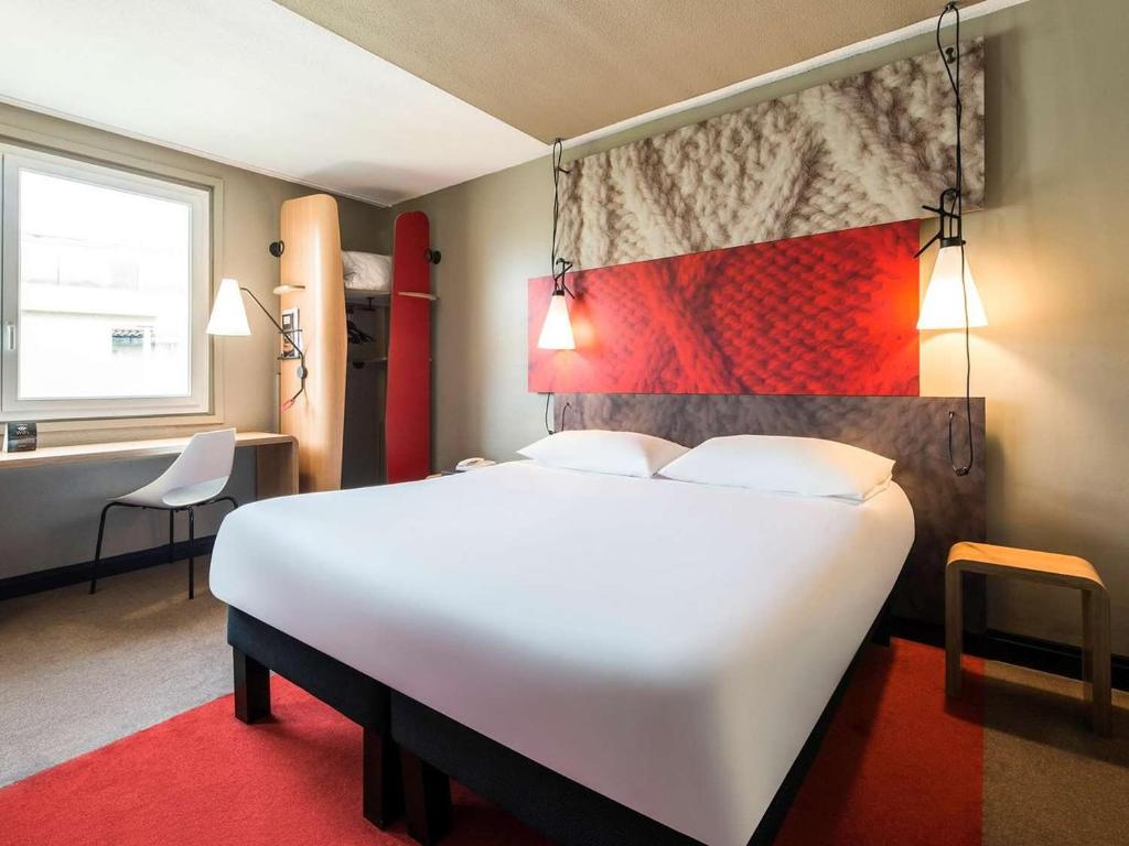 Un dormitorio con una gran cama blanca y una alfombra roja en ibis Parauapebas, en Parauapebas