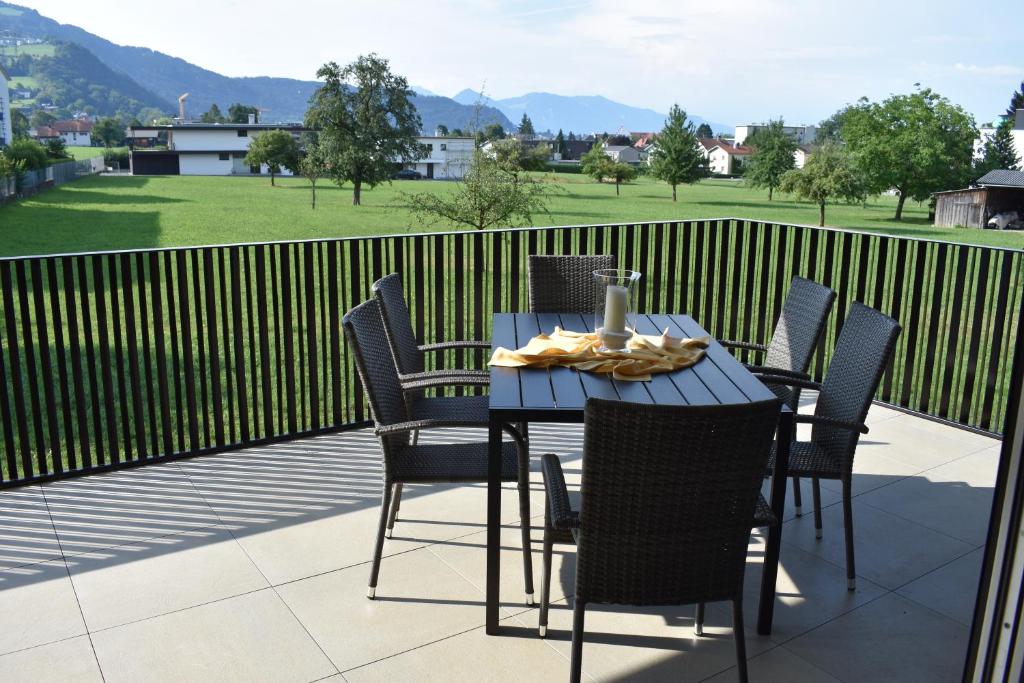 una mesa y sillas en un patio con vistas a un campo en Zweite Heimat, en Lochau