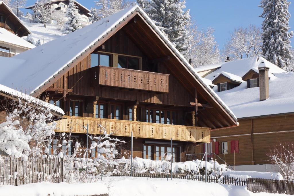 ein schneebedecktes Haus mit einem Zaun in der Unterkunft Ackaert Ferienwohnung Top of Thun in Thun