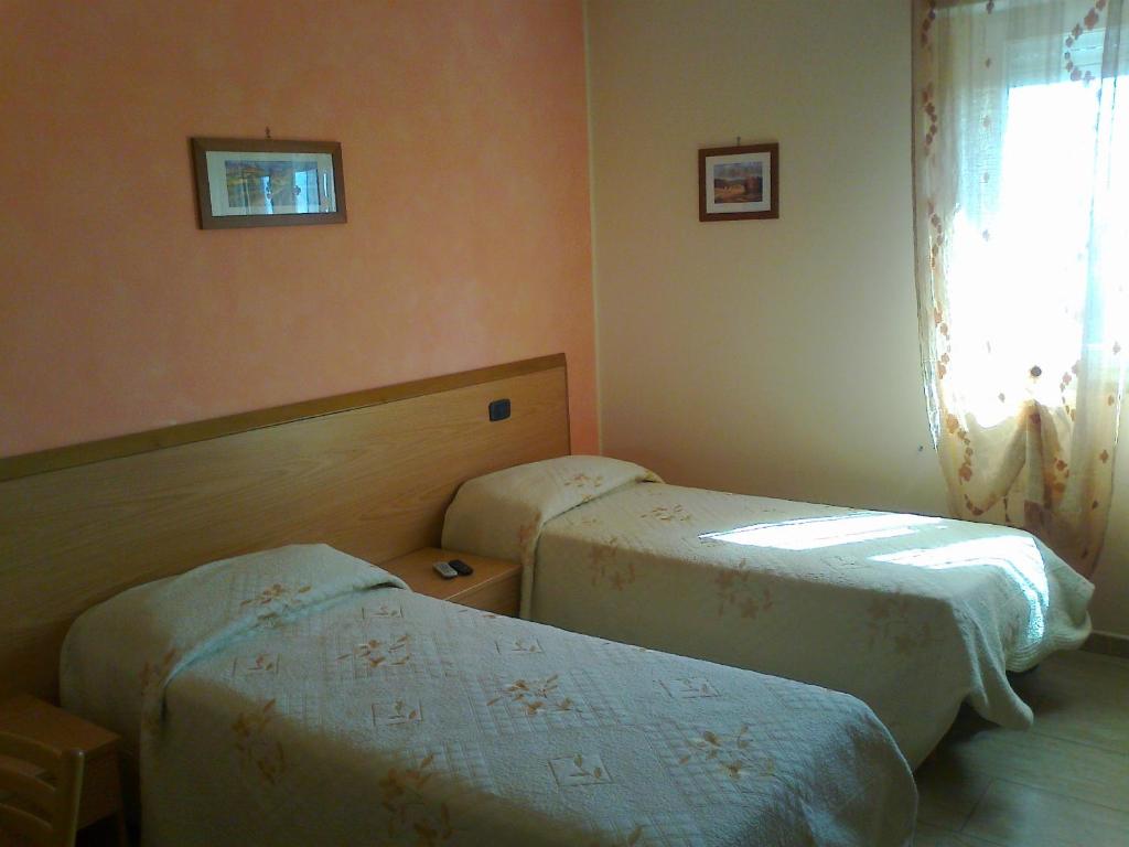 a hotel room with two beds and a window at Life Hotel in Ariano Irpino