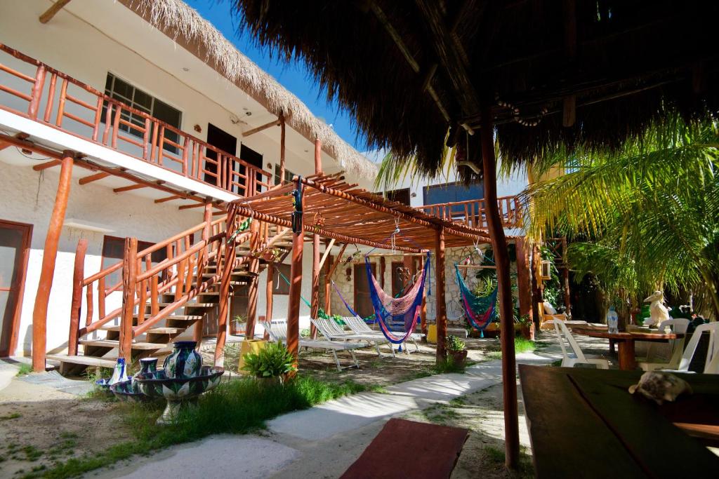 a resort with a deck and chairs and a patio at Golden Paradise Town in Holbox Island
