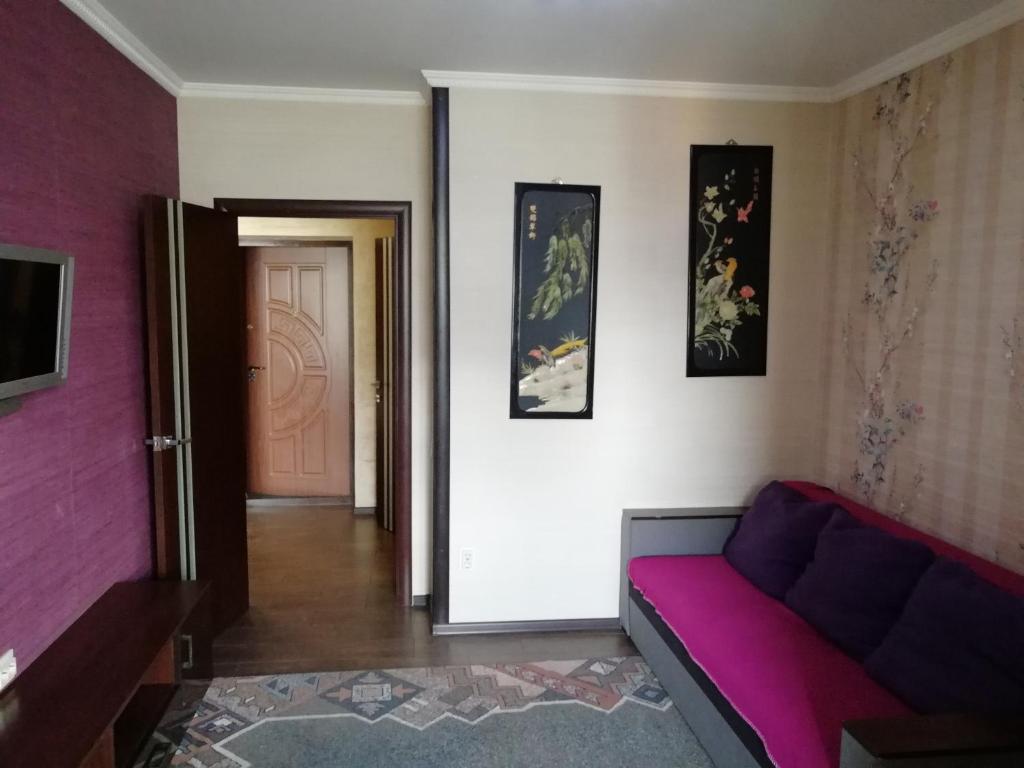 uma sala de estar com um sofá e uma parede rosa em Daily rent Apartments 4 em Ivano-Frankivsʼk