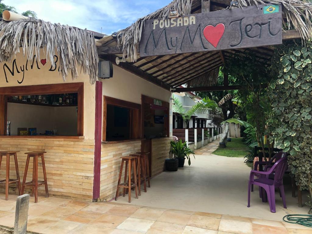 a restaurant with stools and a bar with a sign at Pousada MYM JERI ate 3x in Jericoacoara