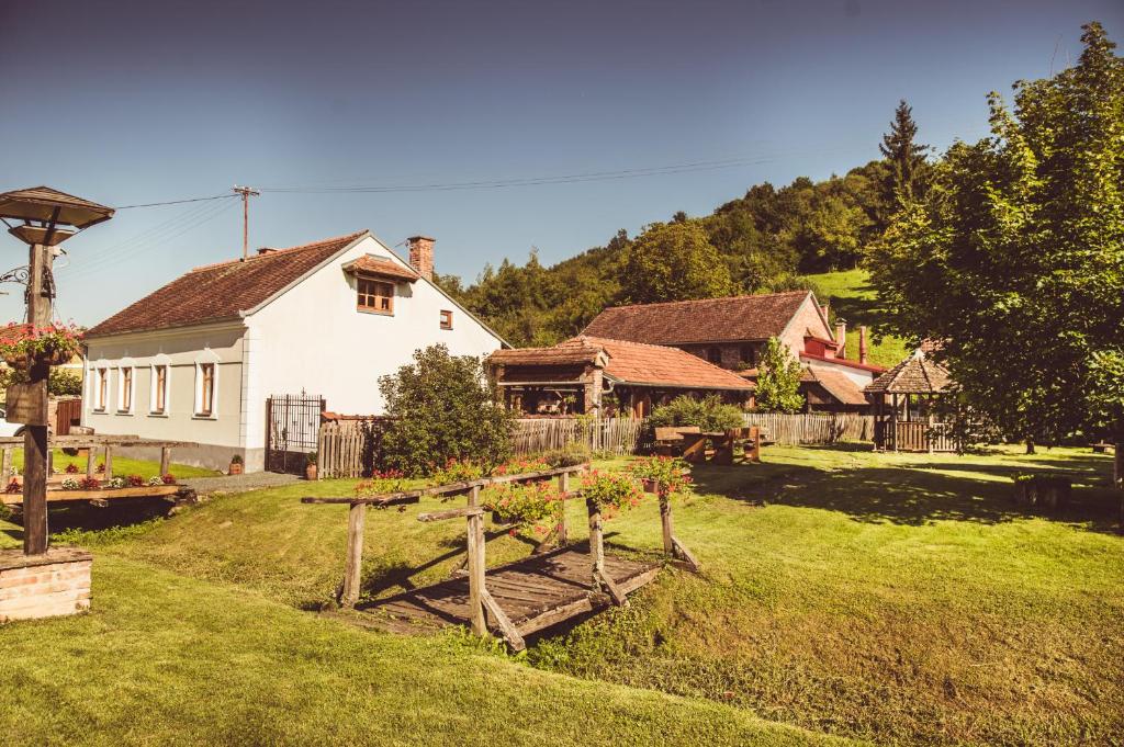 una casa con un patio con un banco de madera en Country House Tunjina kuca Stara Kapela, en Pavlovci