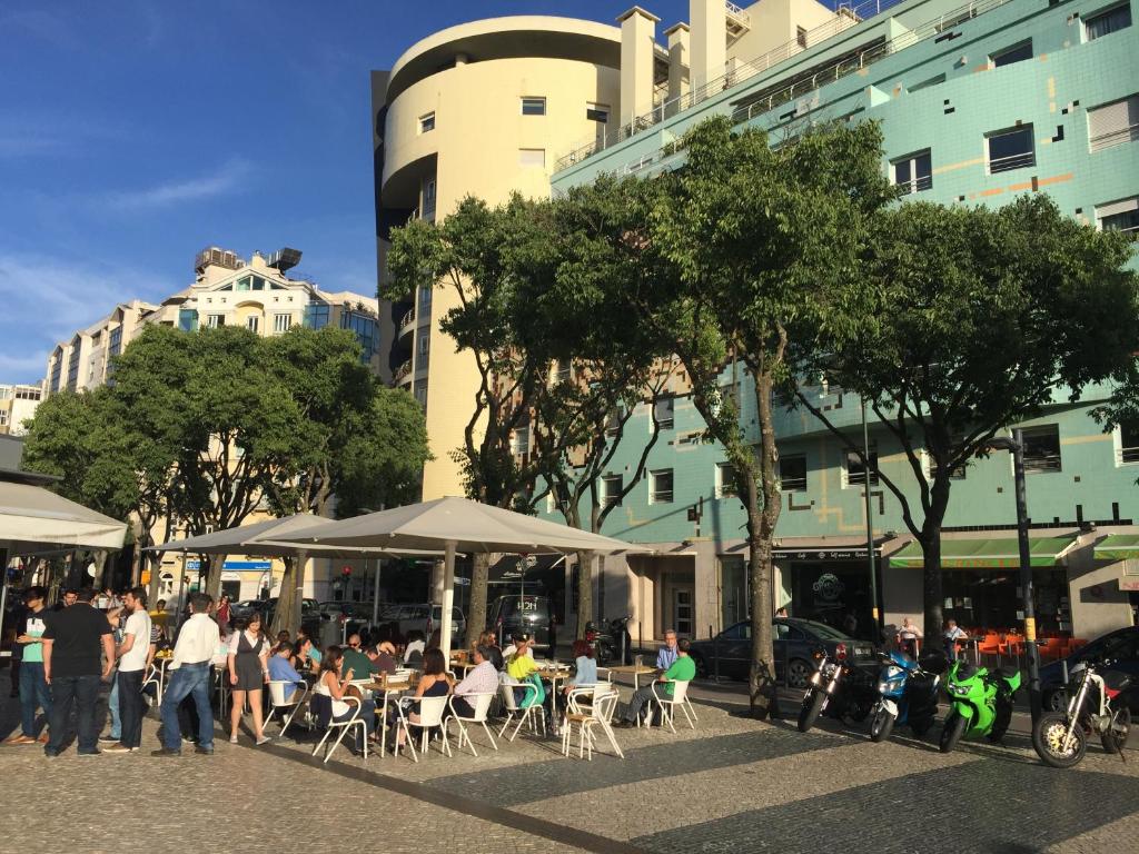 a group of people sitting at tables in a city at 8-bit-building in Lisbon