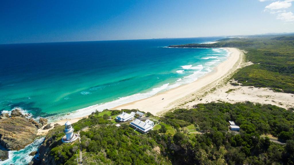 an aerial view of a beach with a lighthouse at Seal Rocks Lighthouse Cottages in Seal Rocks