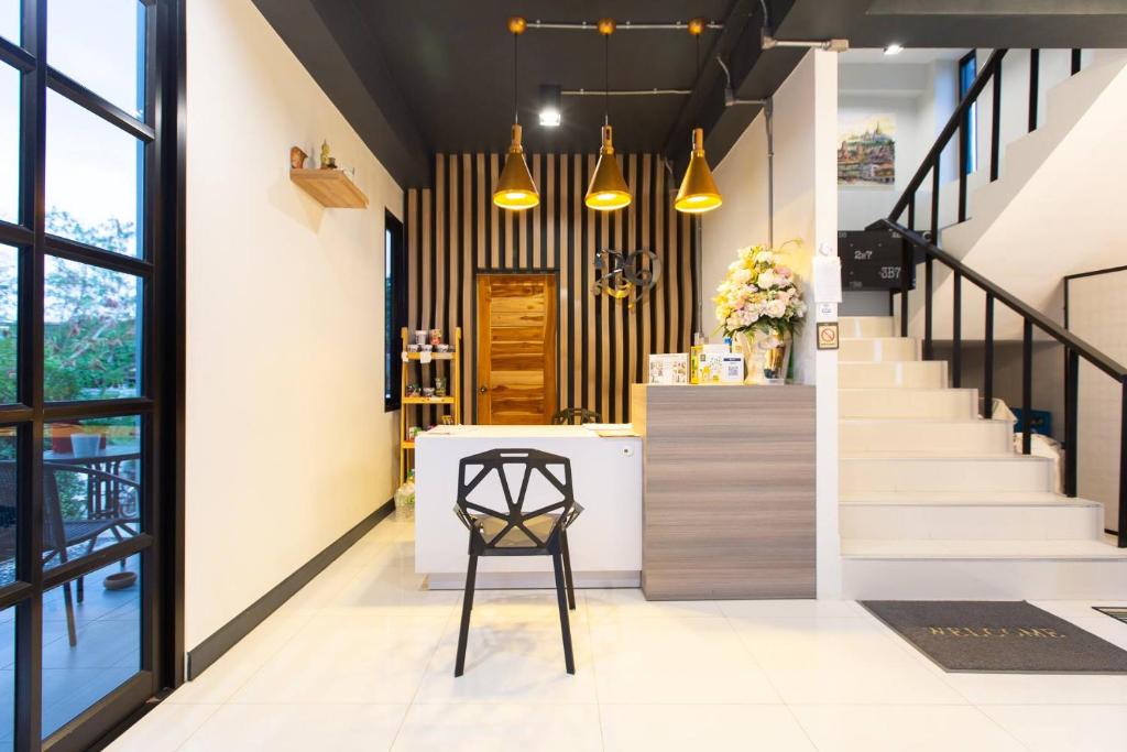a lobby with stairs and a chair and a counter at The 29 place in Nakhon Ratchasima