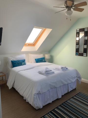 a bedroom with a white bed with a skylight at Inn Glastonbury - Self Catering in Glastonbury