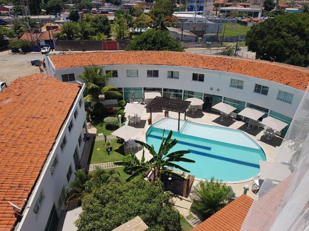 an aerial view of a building with a swimming pool at Mandakaru Flats De Luxo in Porto De Galinhas