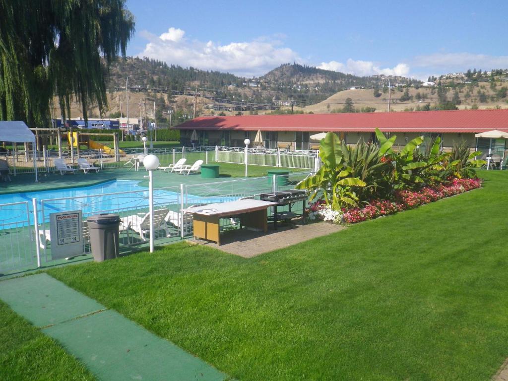 uma piscina com uma mesa de piquenique ao lado de um edifício em Okanagan Seasons Resort em Kelowna