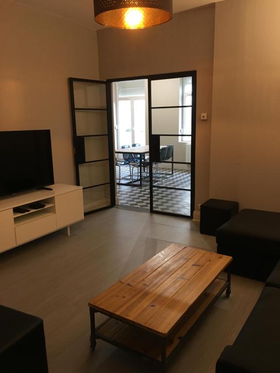 - un salon avec une table basse et une télévision dans l'établissement la terrasse wimereusienne, à Wimereux