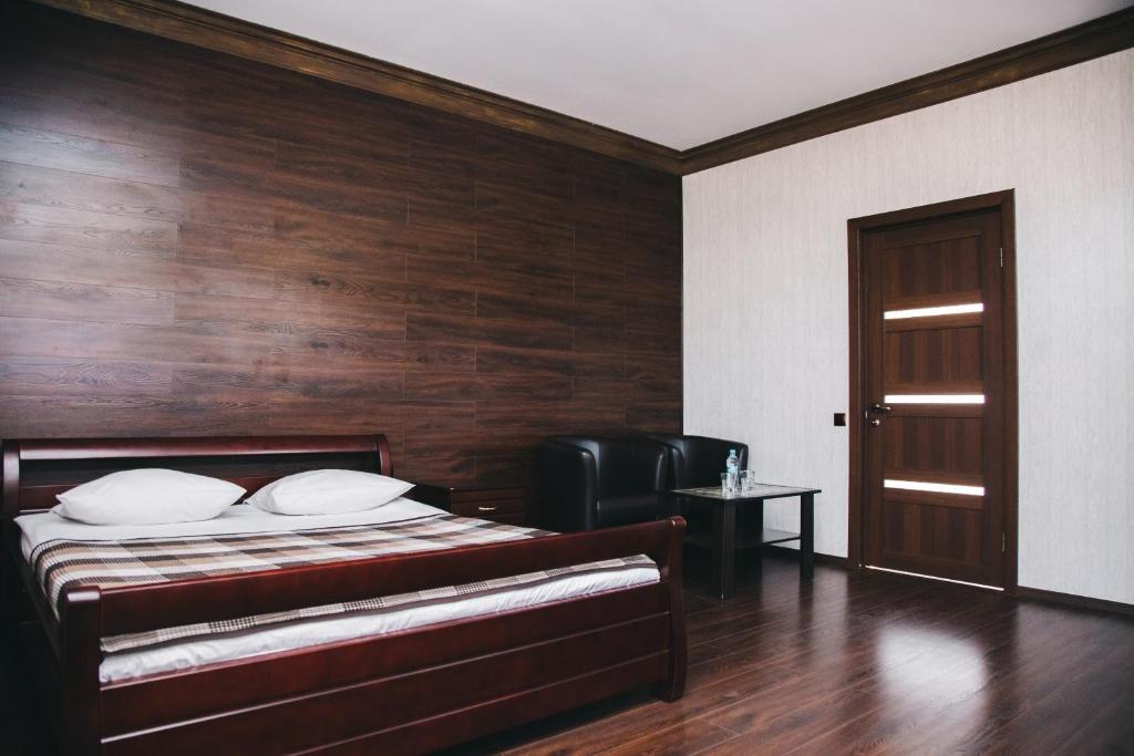 een slaapkamer met een bed en een houten muur bij Вояж Луцьк in Loetsk