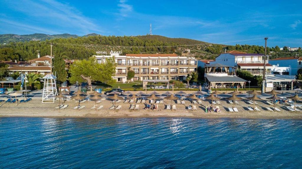 un grupo de sillas y sombrillas en una playa en Hotel Areti, en Neos Marmaras