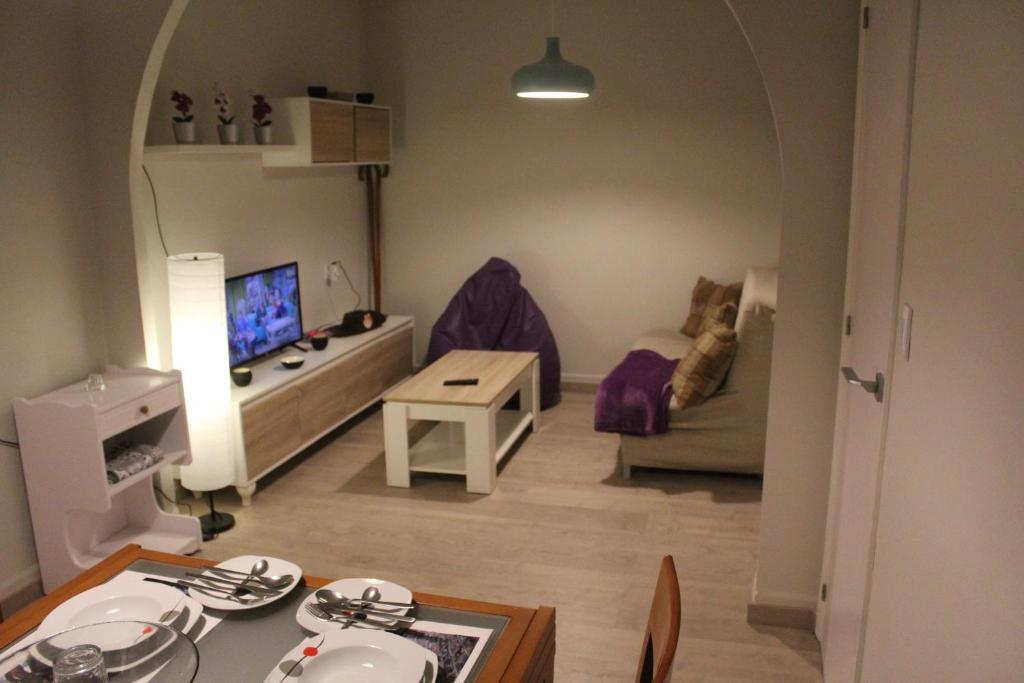 una pequeña sala de estar con sofá y mesa. en Acogedora casa al lado de Padrón VUT-CO-02999, en Padrón