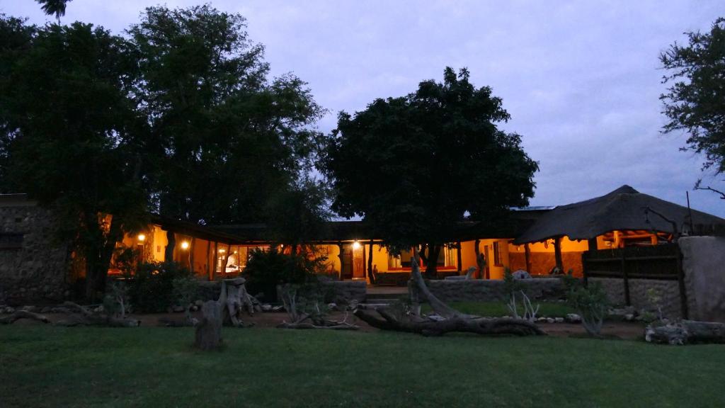 a house lit up at night with lights at Adonsonia Lodge in Grietjie Game Reserve