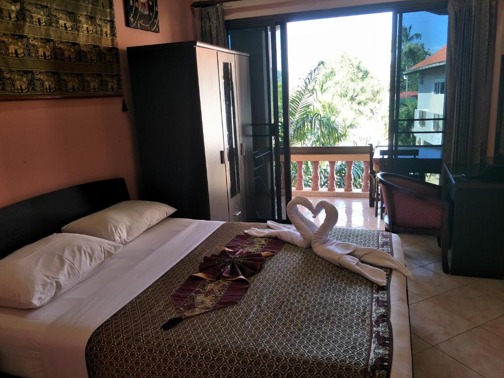 a bedroom with a bed with a pair of hearts on it at Thalassa in Nai Harn Beach