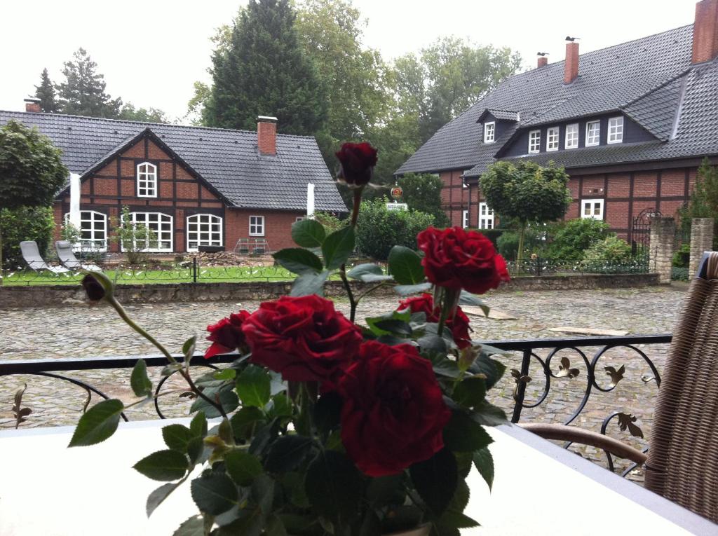 un jarrón de rosas sentado en una mesa frente a una casa en das "Village House" in Volkse en Volkse