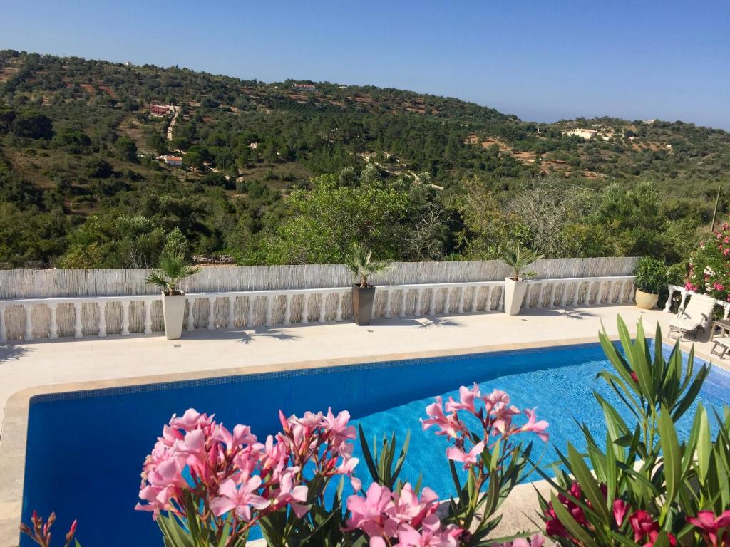 a swimming pool with flowers in front of a fence at Chambre d Hôte exclusif Naturiste et Nudiste CASA AMSYL adultes only in Paderne