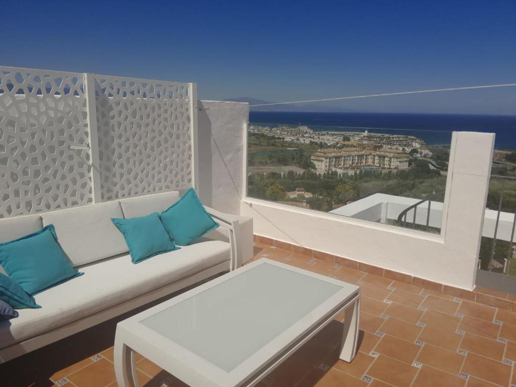 a couch on a balcony with a view of the ocean at Superbe Penthouse vue époustouflante 180 degrés face à la mer # in Castillo de Sabinillas