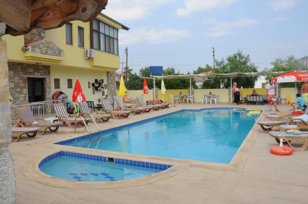 a pool at a hotel with lounge chairs and tables at Ada Apart Hotel in Dalyan