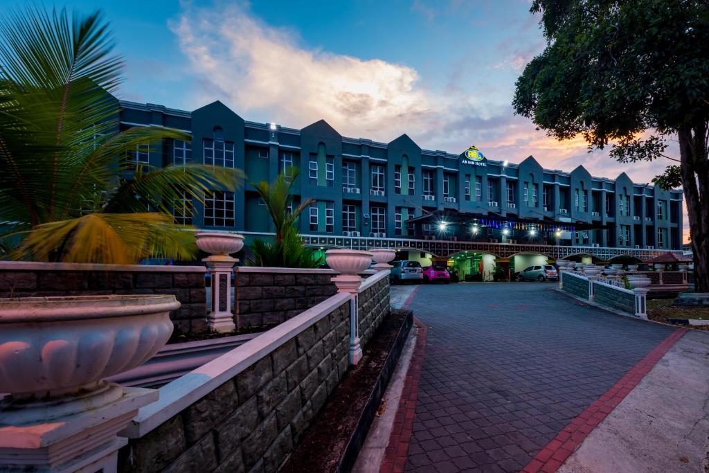 un gran edificio con un patio delante de él en AB Inn Hotel, en Kulai