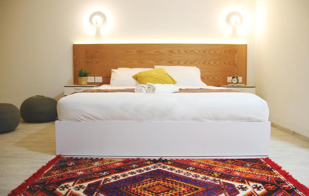 a bedroom with a large bed with a rug on the floor at LAMITA in Majdal Shams