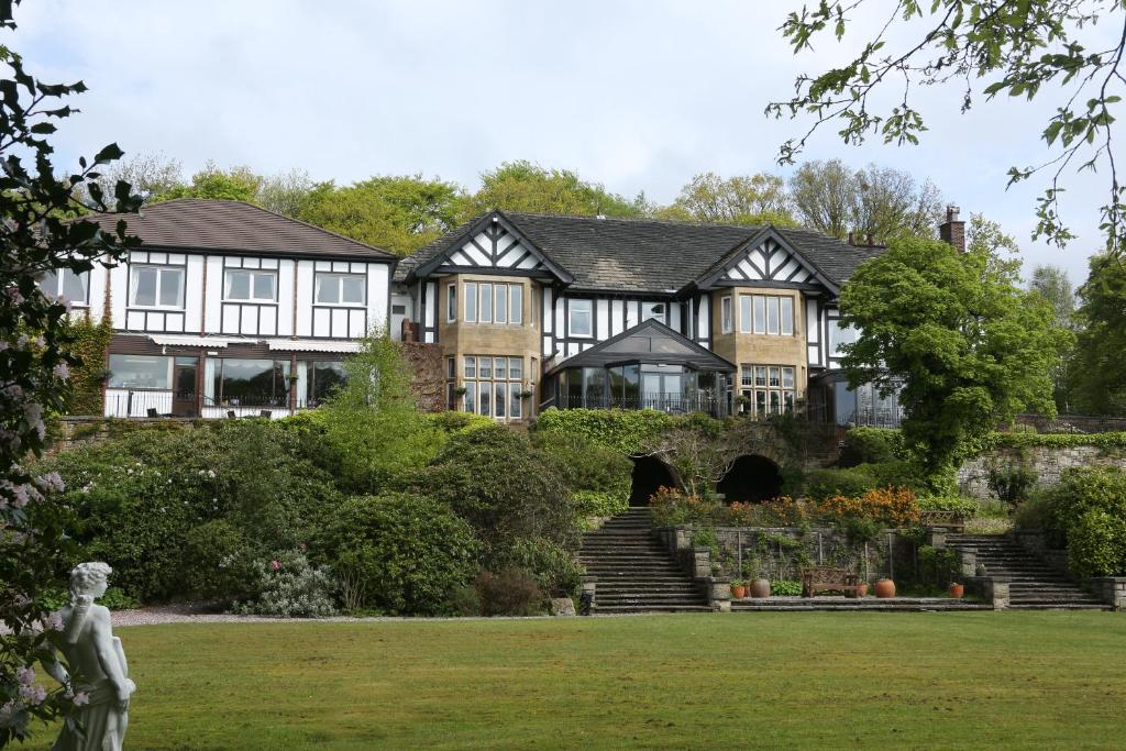 a large house with a statue in front of it at Burnley West Higher Trapp Hotel in Padiham