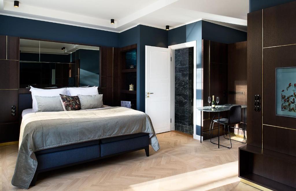 a bedroom with blue walls and a bed and a table at Spinoza Suites in Amsterdam