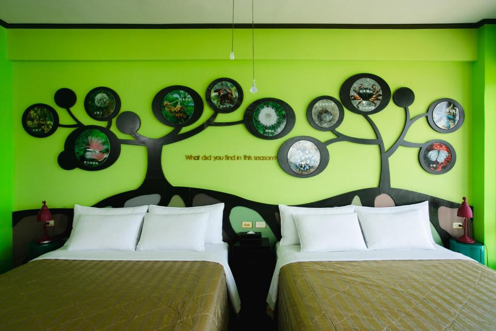 a green room with two beds and plates on the wall at Blue Ocean Sunny BS in Checheng