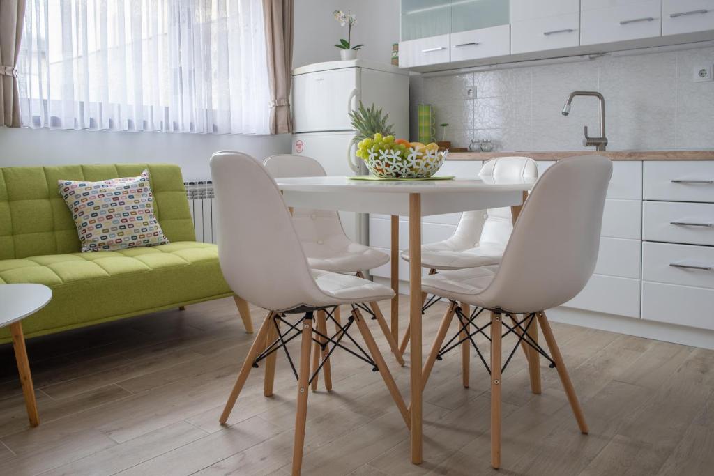 una cocina con mesa y sillas y un sofá verde en Apartment Vir, en Karlovac