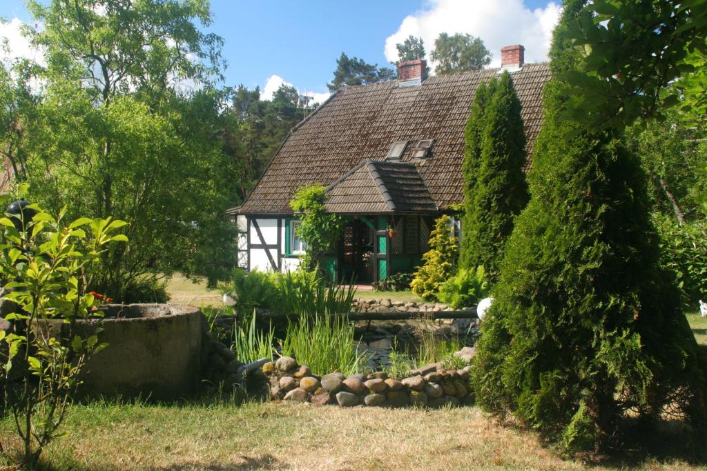 una casa vieja con un estanque delante de ella en Agroturystyka Stajnia Horyzont, en Jarosławiec
