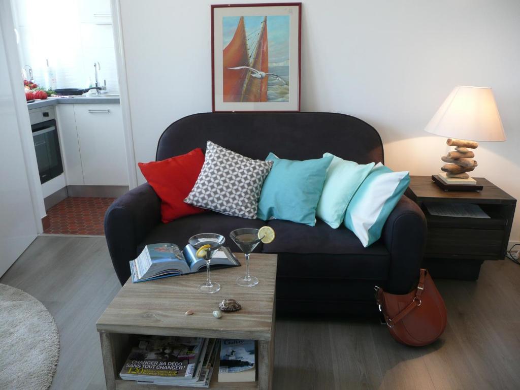 a living room with a black couch with colorful pillows at Escale marine à Calais 4 étoiles in Calais
