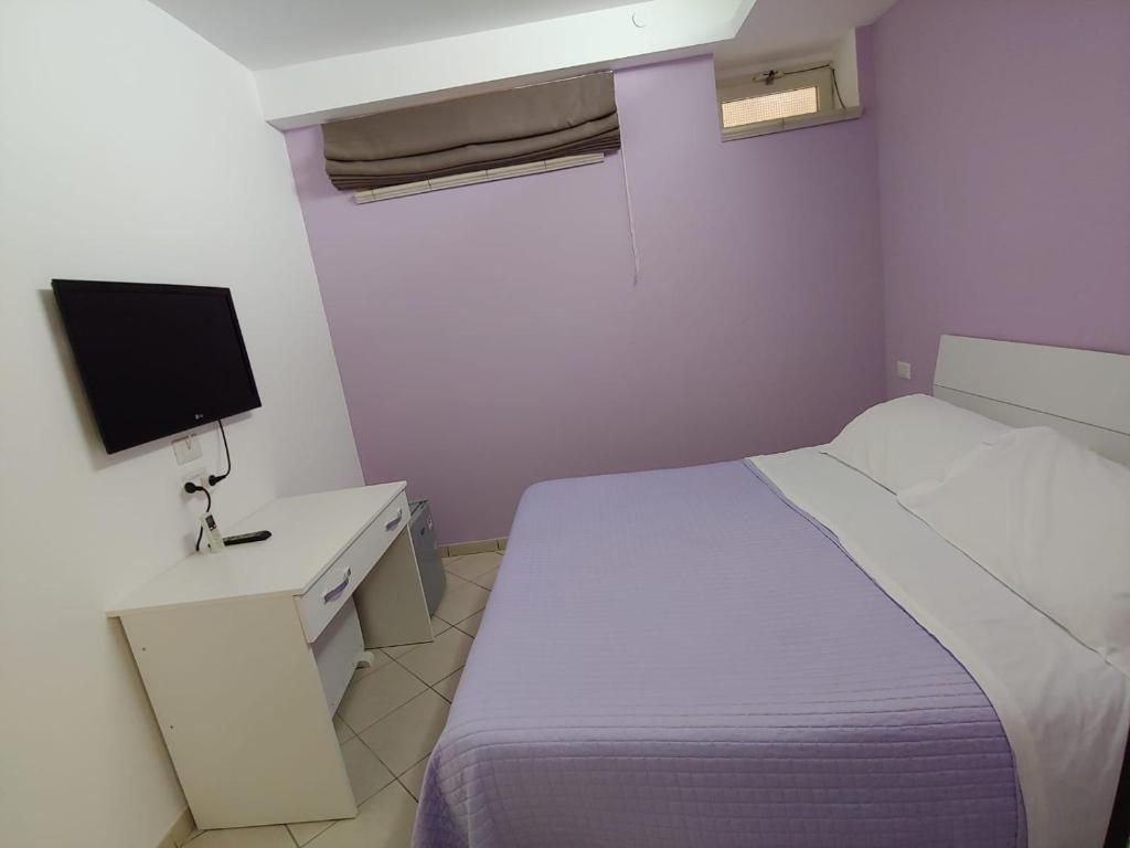 - une petite chambre avec un lit et une télévision dans l'établissement SORRENTO RELAIS BASEMENT, à Sorrente