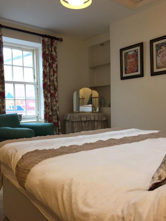 a bedroom with a large bed and a window at Eden's House in Hexham