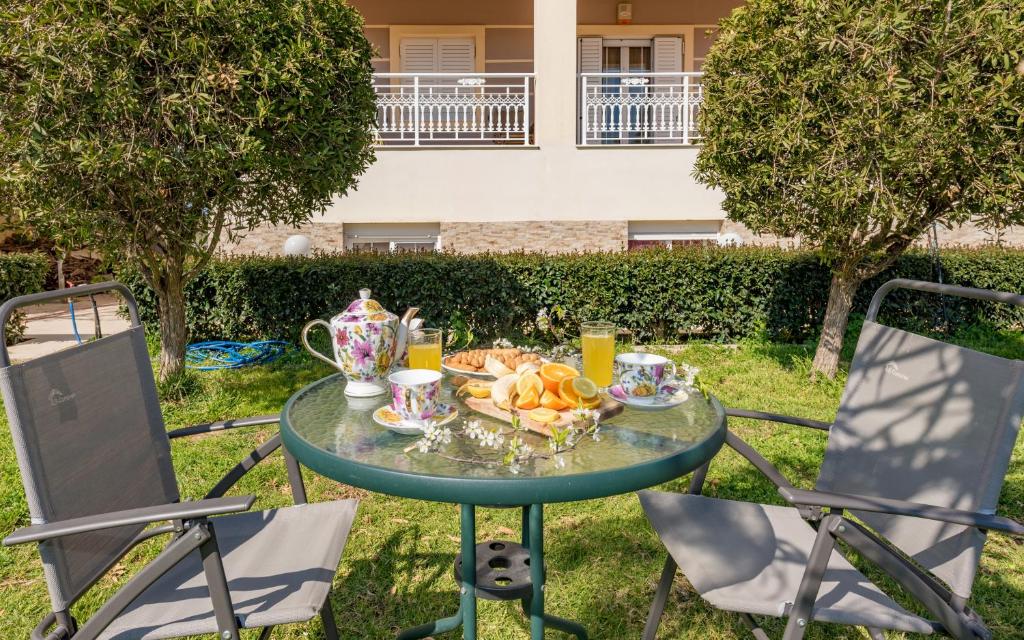 a table with a plate of food and two chairs at Eleni's cozy apartment in Tsilivi in Gaïtánion