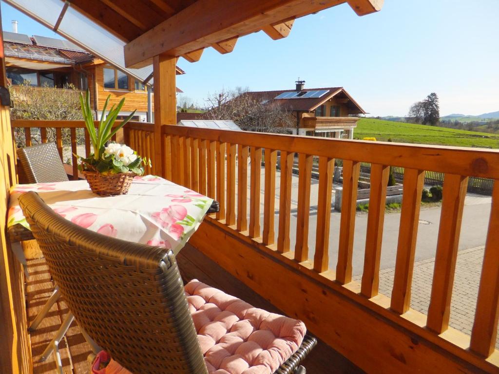 a wooden deck with a table and chairs on a balcony at Ferienwohnung Alpenstern in Rieden am Forggensee