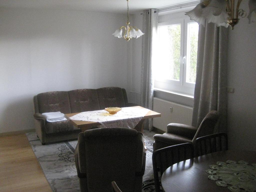 Ferienwohnung mit Aegidienblick في Oschatz: غرفة معيشة مع أريكة وطاولة وكراسي