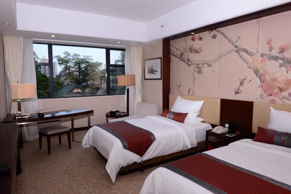 Postel nebo postele na pokoji v ubytování Guangdong Yingbin Hotel-Free Canton Fair Shuttle Bus