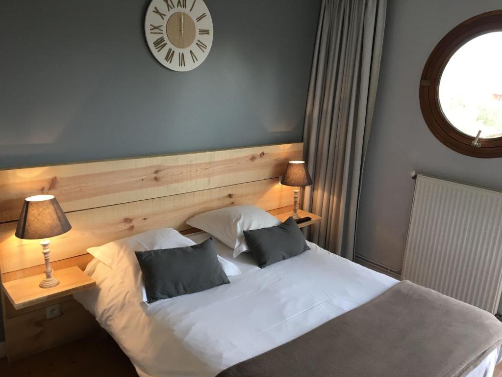 Un pat sau paturi într-o cameră la Le Pavillon Bleu