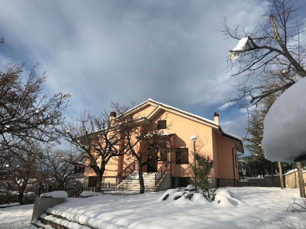 uma casa com neve no chão em frente dela em Villa Miralago em Fiastra