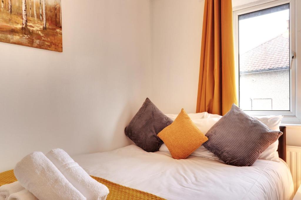 a bedroom with a bed with pillows and a window at Walter House in Edgware