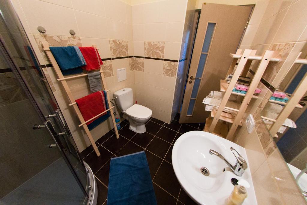une salle de bains avec lavabo, toilettes et douche dans l'établissement Suitu apartments, à Liepāja
