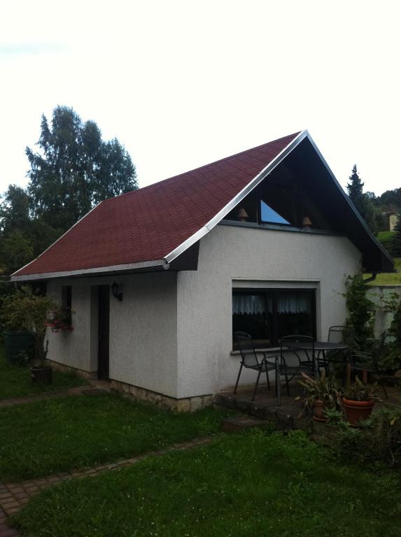Biały dom z czerwonym dachem i stołem w obiekcie Ferienhaus Dani w mieście Bad Gottleuba