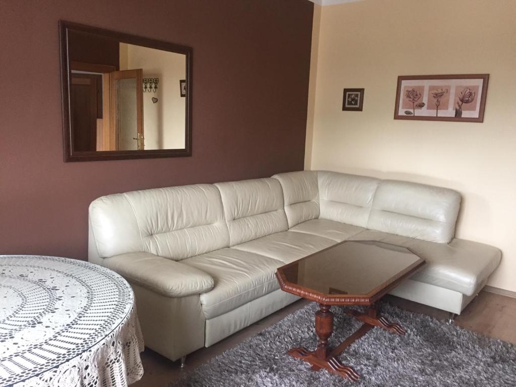 a living room with a white couch and a table at DELI Tatry Apartment in Poprad