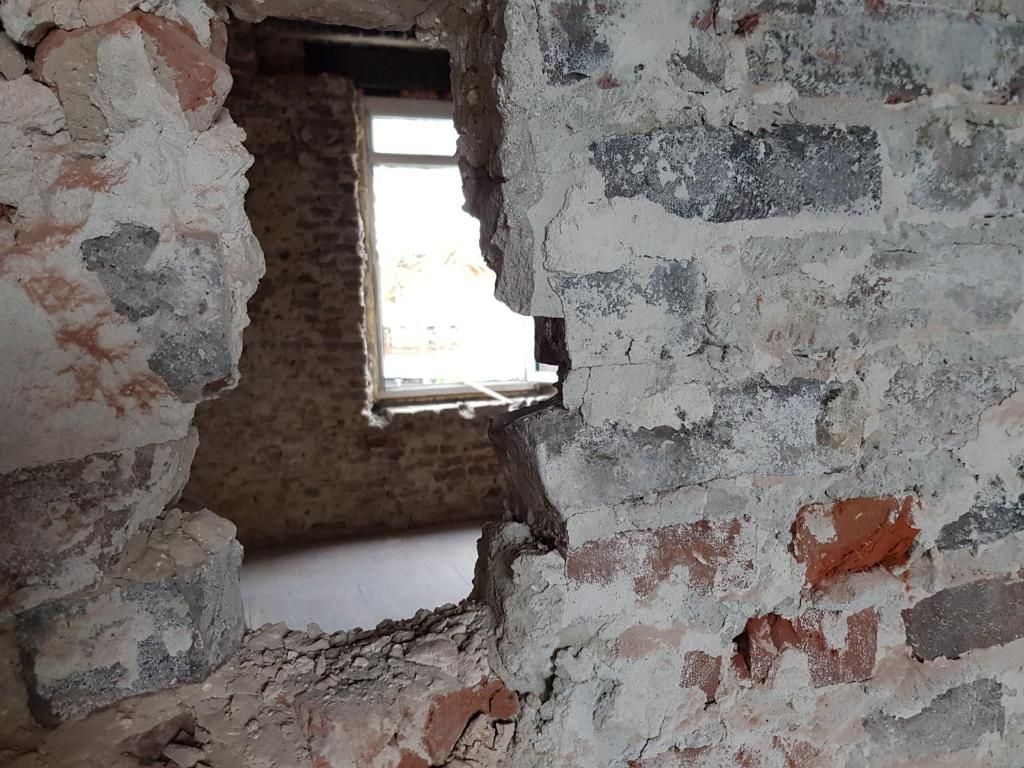 a brick wall with a window in a room with a brick wall at B&B The Project in Heerlen