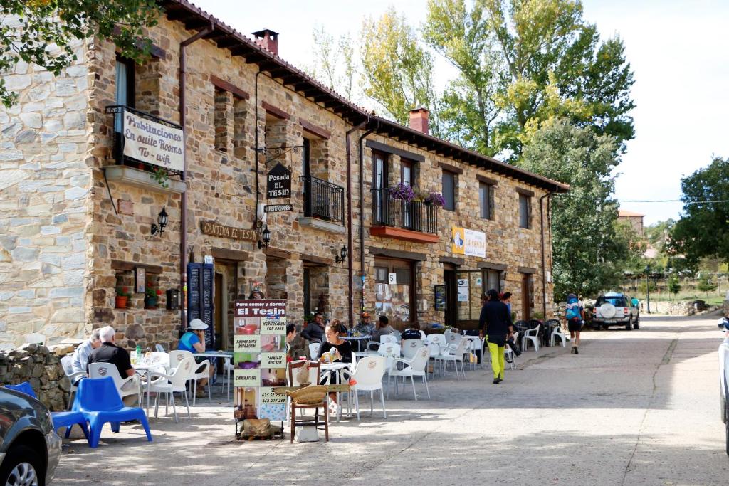 a group of people sitting at tables outside a building at Posada El Tesin in Rabanal del Camino