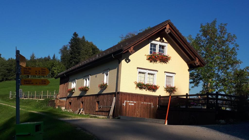 a house with flower boxes on the side of it at Gasthaus Fuchsacker in Degersheim